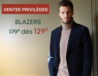 Homme portant un blazer bleu marine et un pull beige